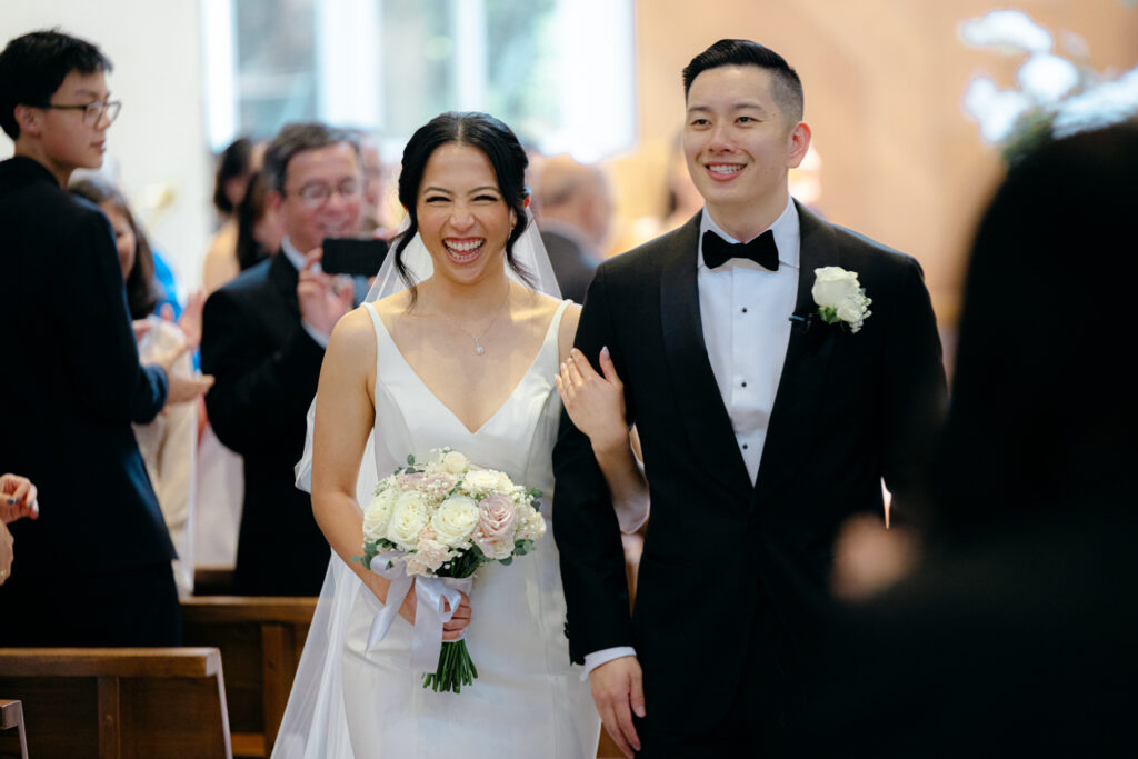 bride and groom walking down the aisle at holy spirit catholic church