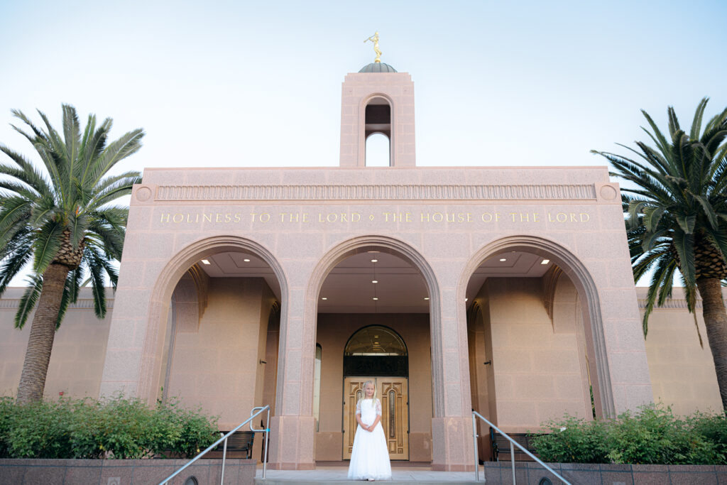 girl in white dress smiling in front of Newport Beach Temple