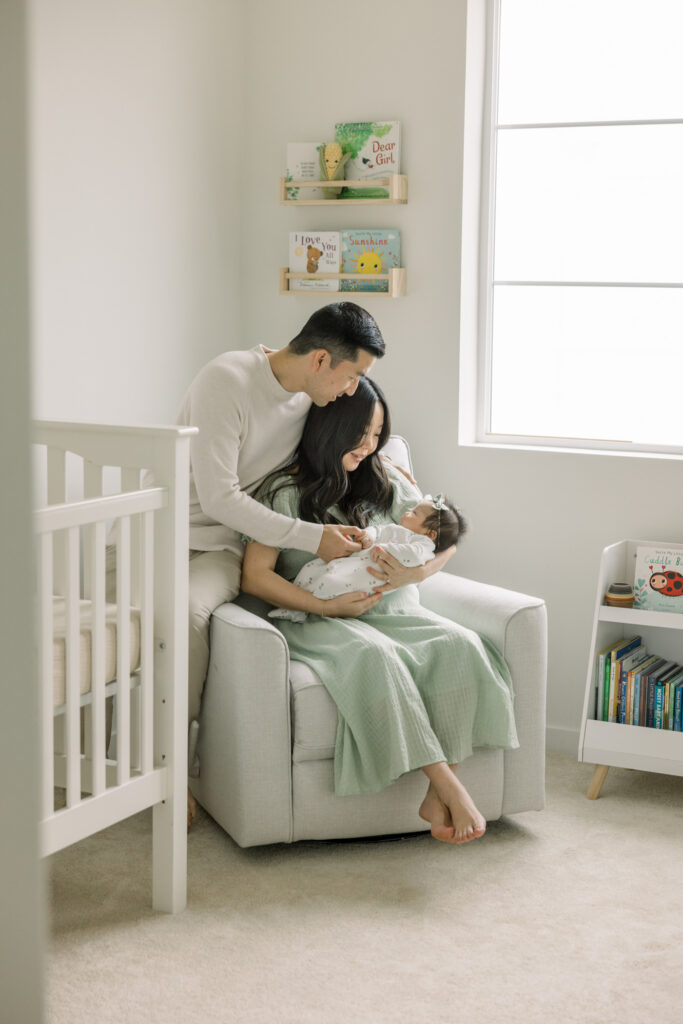 mother and father with baby in nursery